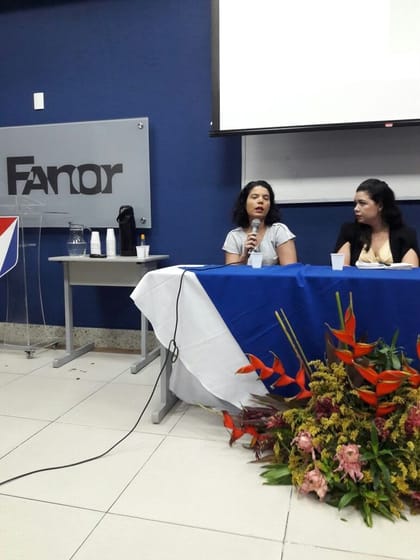 Raisa Arruda em mesa de debate em auditório universitário.