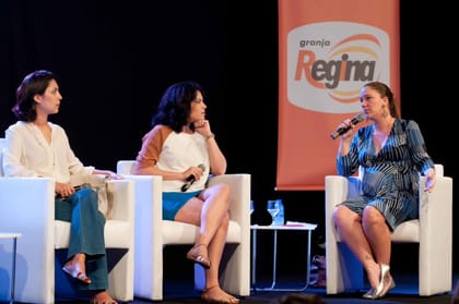 Raisa Arruda em mesa redonda no palco, ao lado de outras participantes.