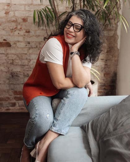 Raisa Arruda sentada em uma poltrona, em ambiente claro, durante atendimento de orientação parental.